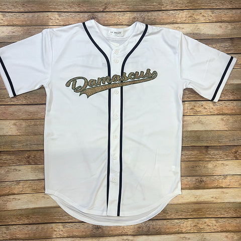 White baseball jersey with black piping and Damascus in a baseball script font in green and gold glitter across the chest.