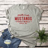 Gray short sleeve t-shirt with red glitter Middle Creek Mustangs Football Apex, NC design. It's a clean and classic old school design.