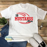 A white short-sleeve crewneck t-shirt with a two-color red and black football with the text of Mustangs Mom running in the middle of the football.