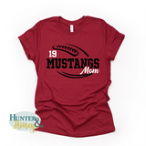 A red short-sleeve crewneck t-shirt with a two-color black and white football with the text of Mustangs Mom running in the middle of the football.