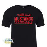 A black ringspun cotton crewneck tee with a red imprint reading Middle Creek Mustangs Football Dad across the chest. 