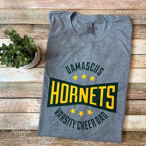 Gray Damascus Hornets Varsity Cheer Dad tee with a two color green and gold logo. 