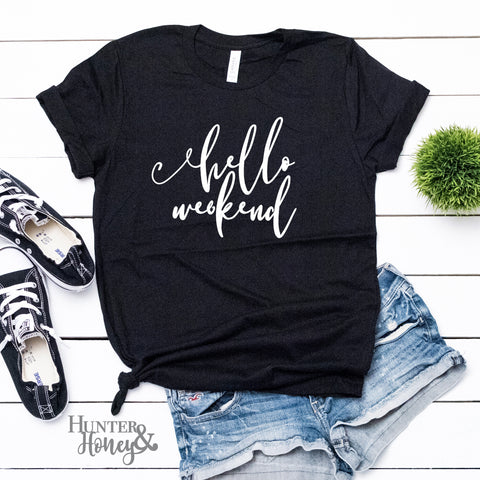 Hello Weekend in white on a black unisex cotton graphic t-shirt.