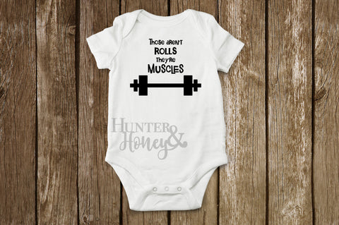 These aren't rolls they're muscles infant bodysuit in white with black lettering.